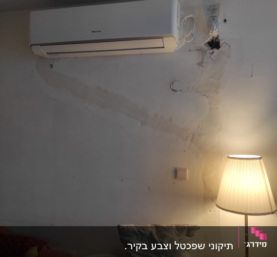 מזגן מותקן על קיר עם חוטי חשמל גלויים